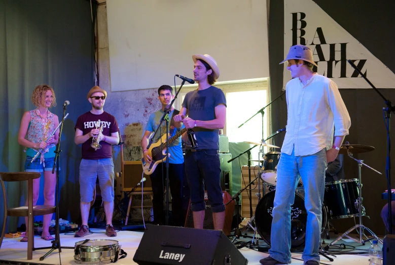 an image of people singing on stage with musical instruments