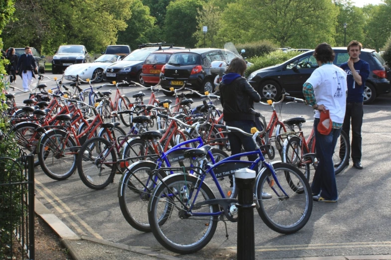 people standing around many bicycles in the street