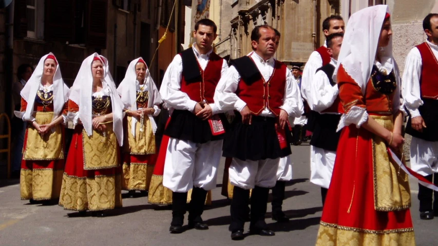 men in traditional clothes are walking on a city street