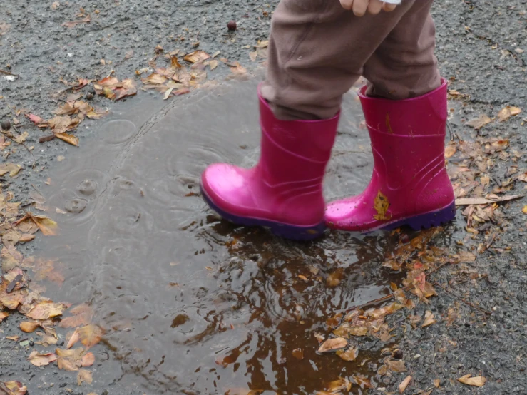 a person with a pink rain boot is standing in a dle