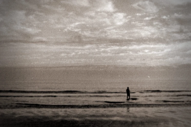 a man stands in the water as he waits for his next wave to surf