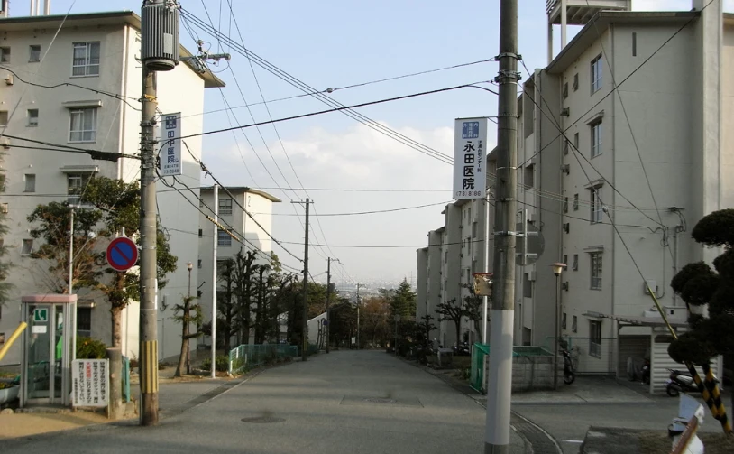 a street with buildings and power lines in the background