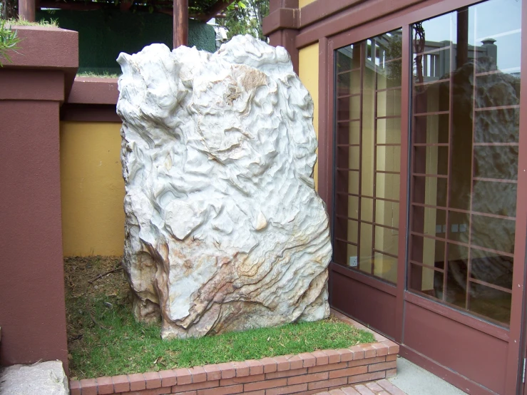 a large rock is sitting in front of a building