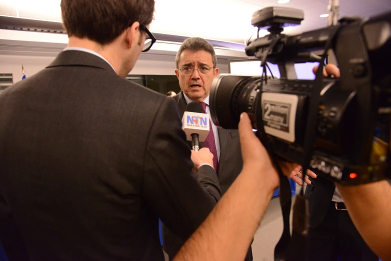 a man with a microphone in front of a camera