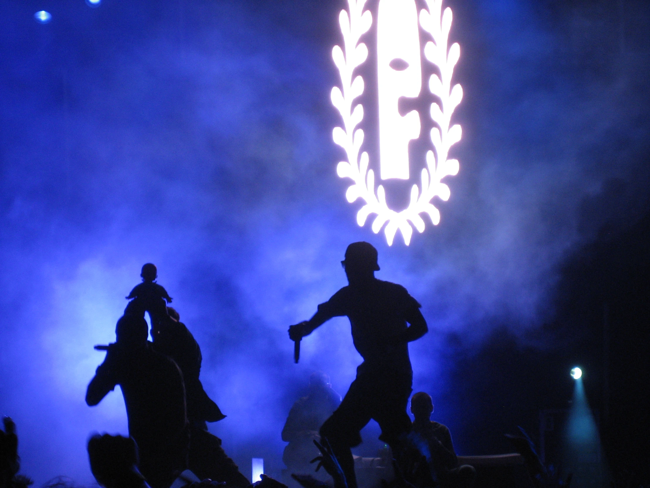 two silhouettes dancing on stage while an object appears in the background