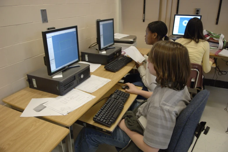 a  sitting at a desk in front of a computer