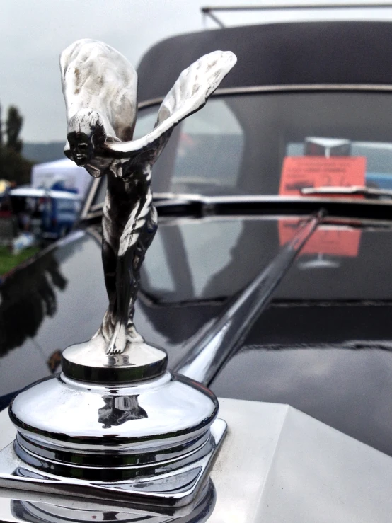 a statue on the hood of a vintage automobile