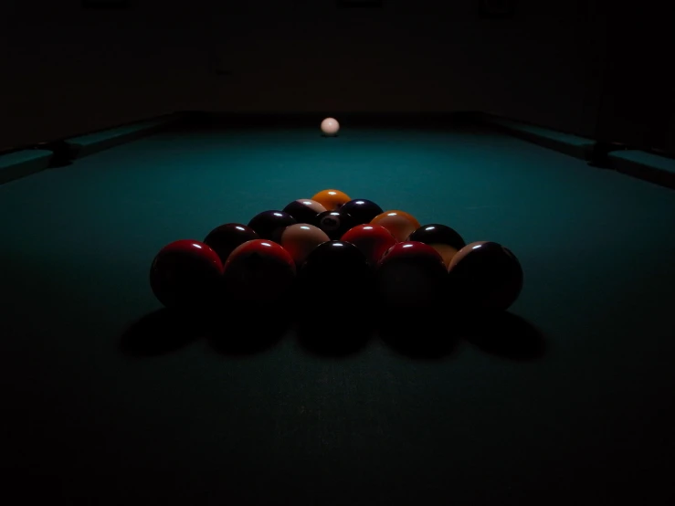 pool balls and cues in dark spot setting with black lights