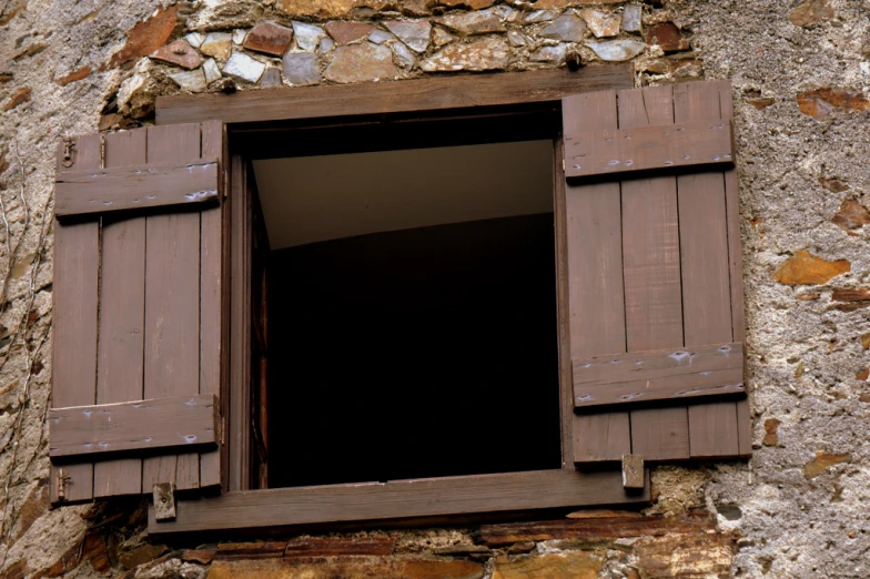 the window has brown wood shutters on it