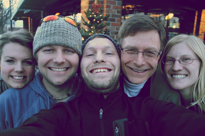 group of smiling men and women taking a selfie