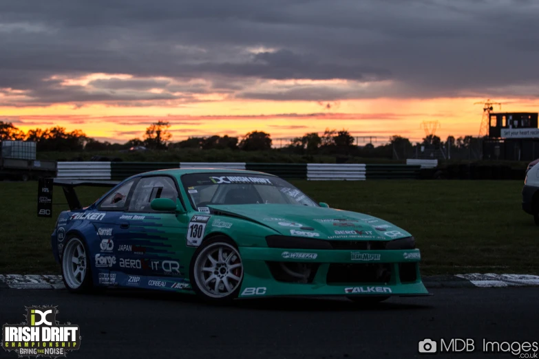 a racing car is going on the track at sunset