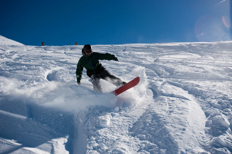 a snowboarder wearing black is going down the mountain