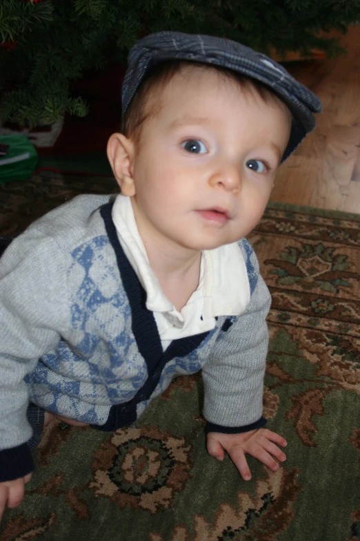 a  wearing a hat and jeans crawling across a carpet