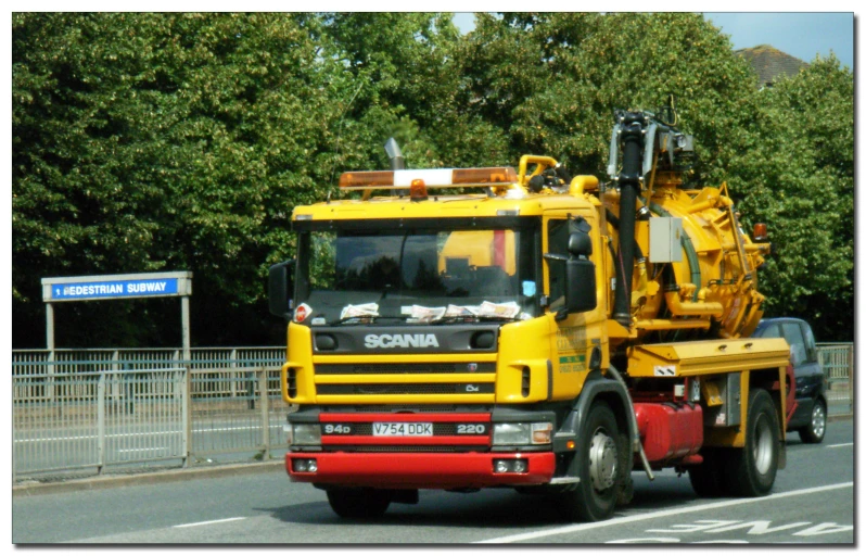 a yellow and red truck is driving down the road