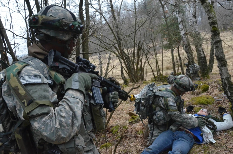 two military men in camouflage are working with each other