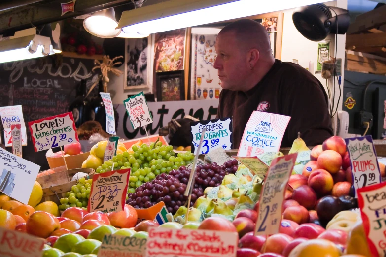 a man looks at fruit displayed for sale at an outdoor farmers market