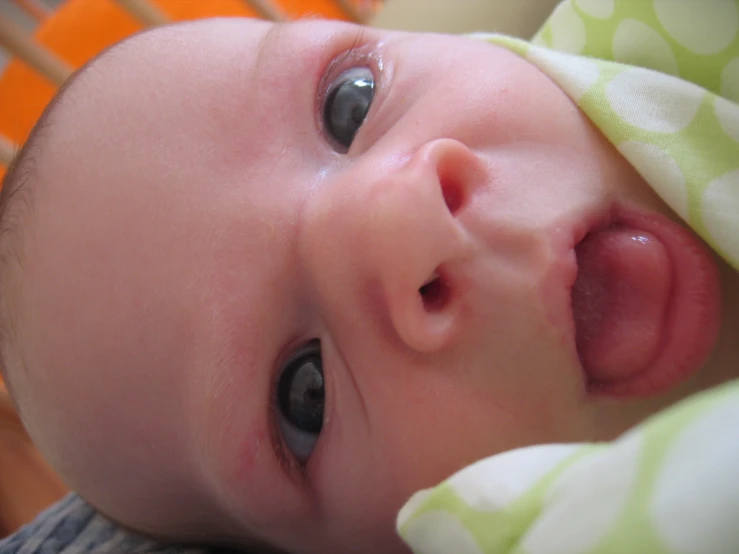 a close up of a baby laying on the ground