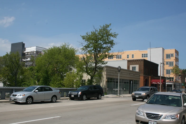 cars are parked on the side of a street near buildings