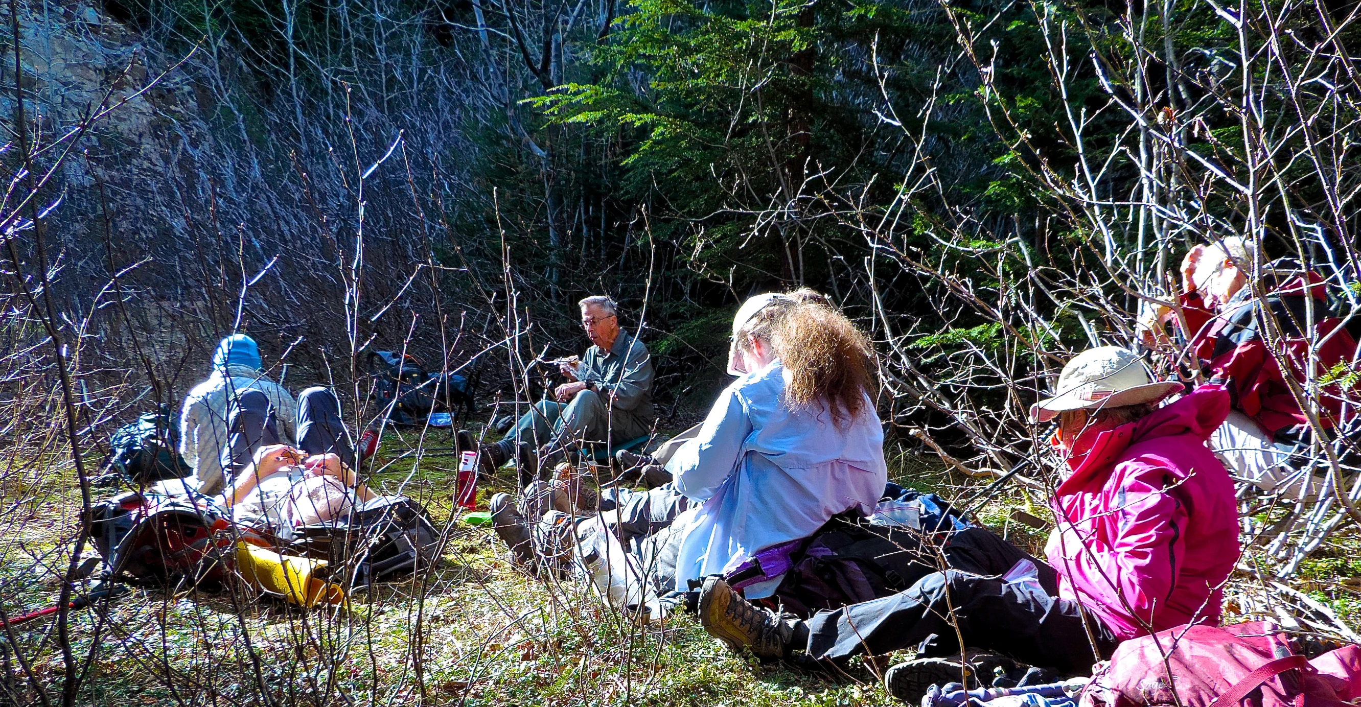 several people in their blankets sitting on the ground while one person takes pictures