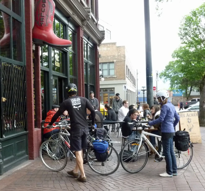 a couple of people standing on the sidewalk with some bikes