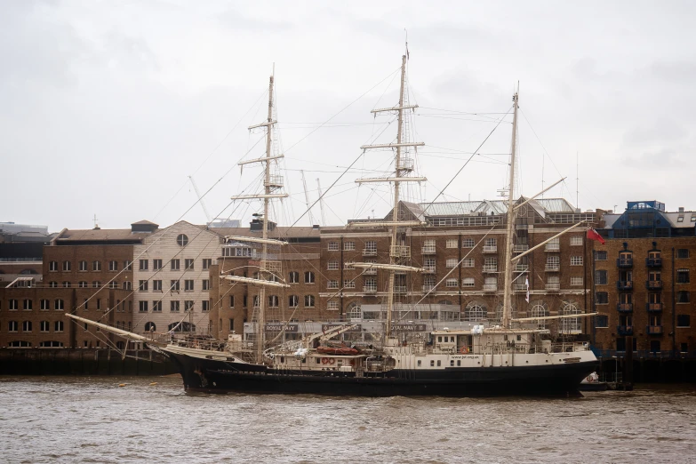 a sail ship docked in a port with buildings