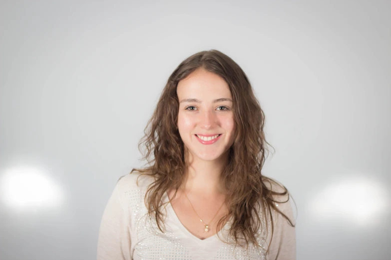 a woman in a white shirt smiling at the camera