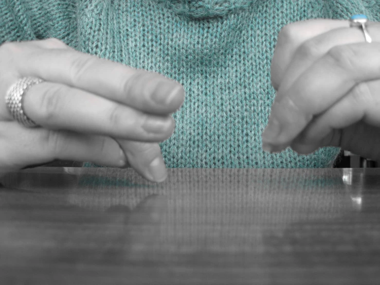 two people hold hands over an object on a table