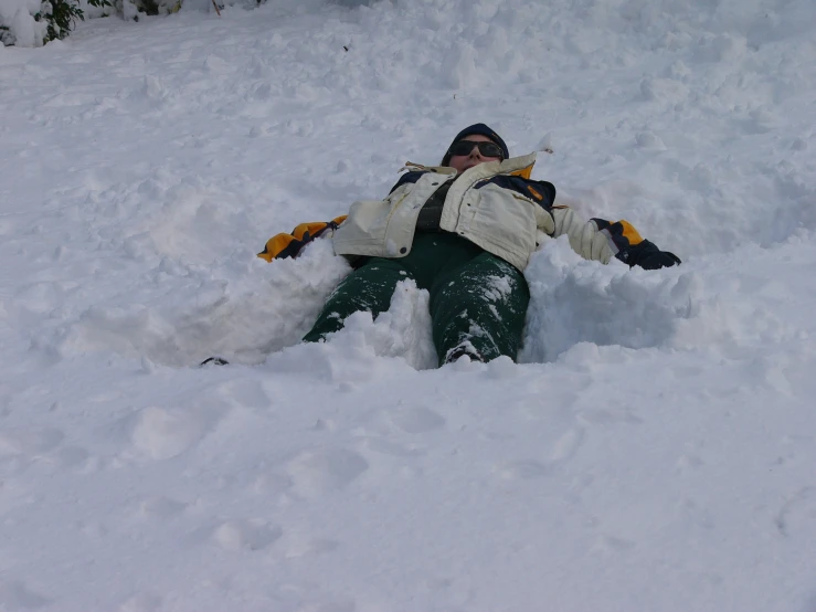 a person in snow gear laying on top of the snow