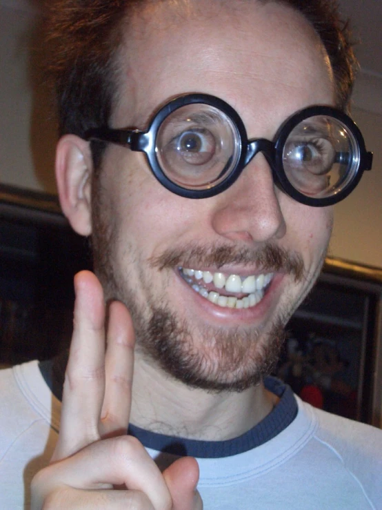 a man in glasses is smiling for the camera