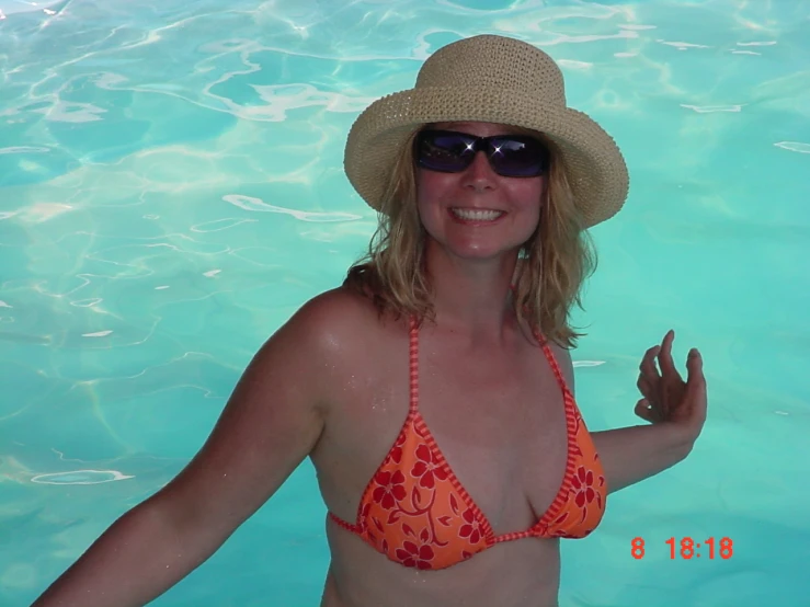 a woman in a bikini wearing a hat and sunglasses