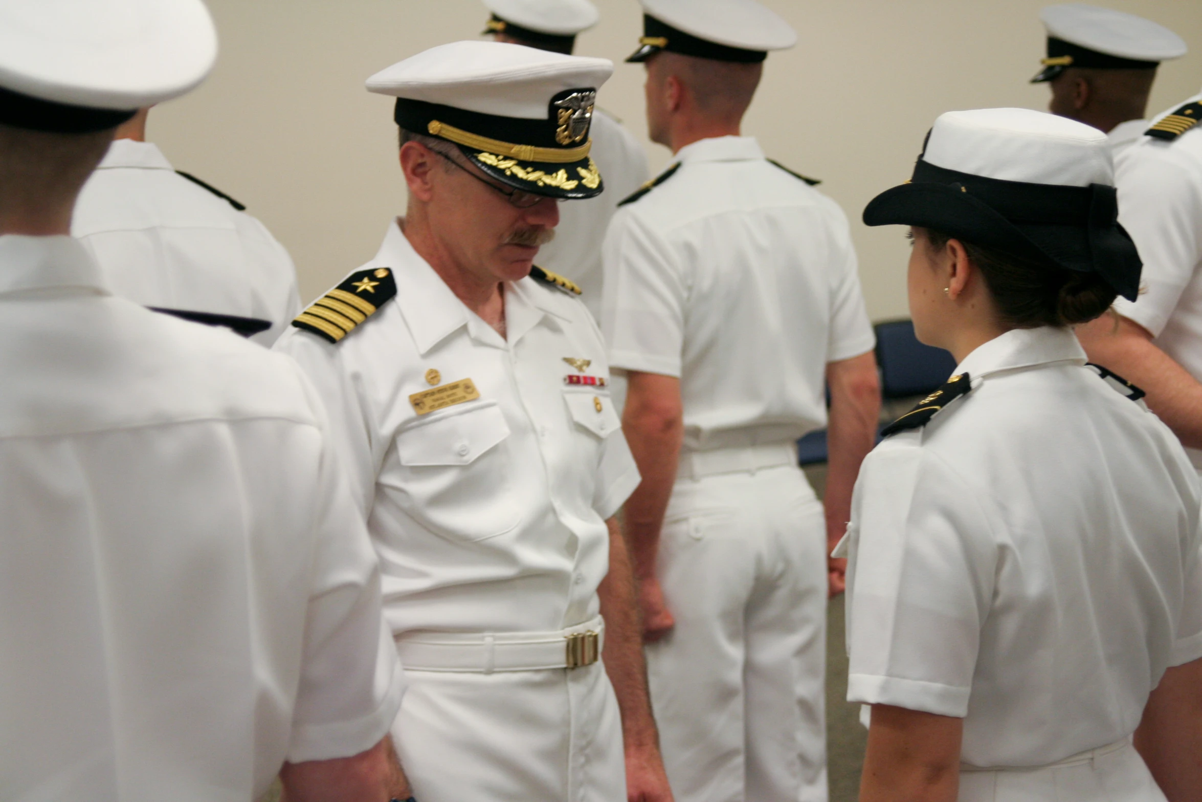 a group of sailors talking to each other in uniform