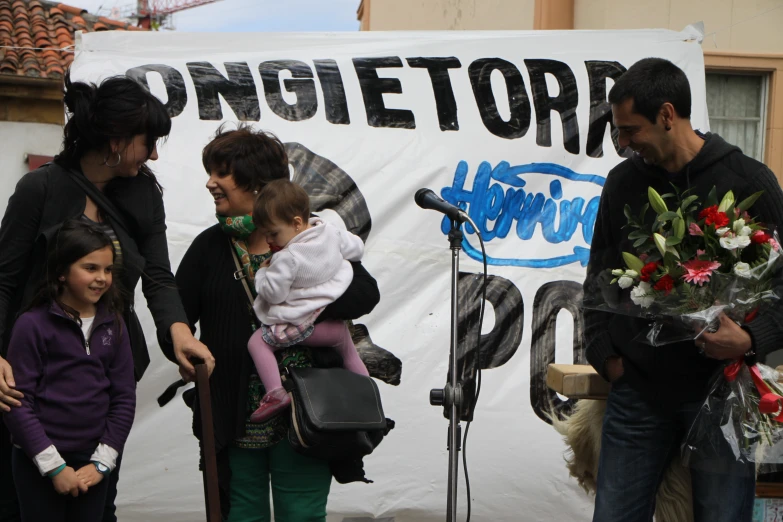 a group of people standing next to each other in front of a microphone