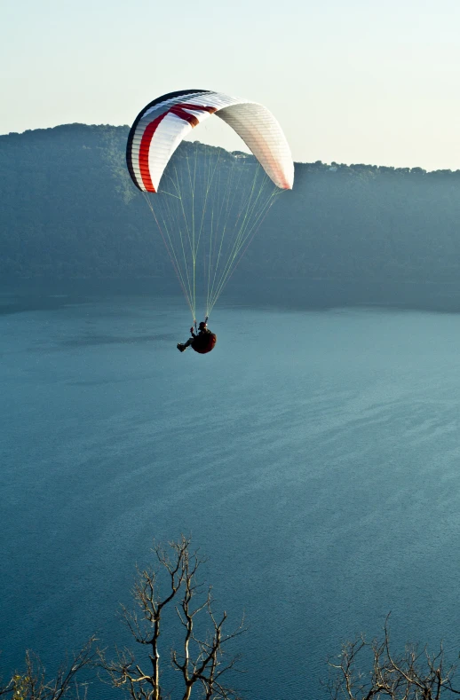 a man riding a parachute over a body of water