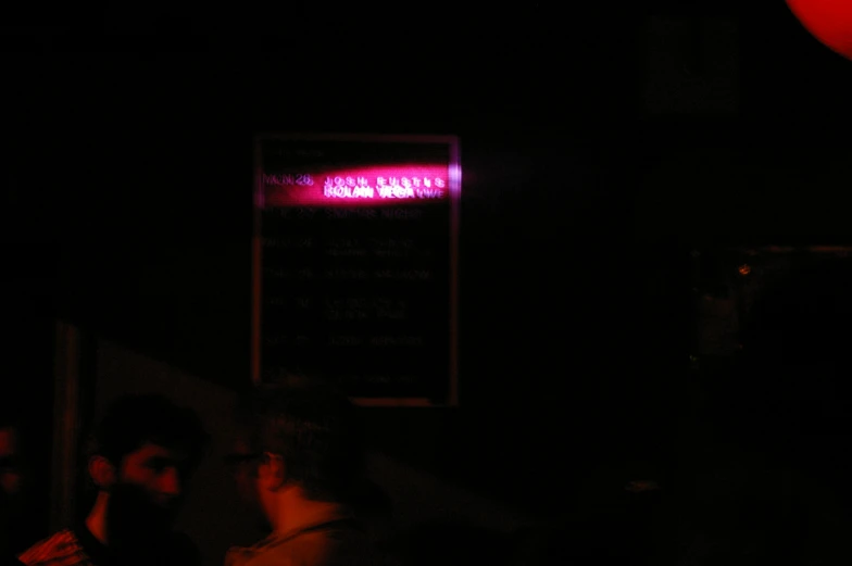 the neon sign is on display at night in the dark