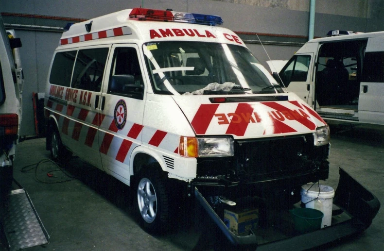 the front and back of an ambulance parked inside of a building