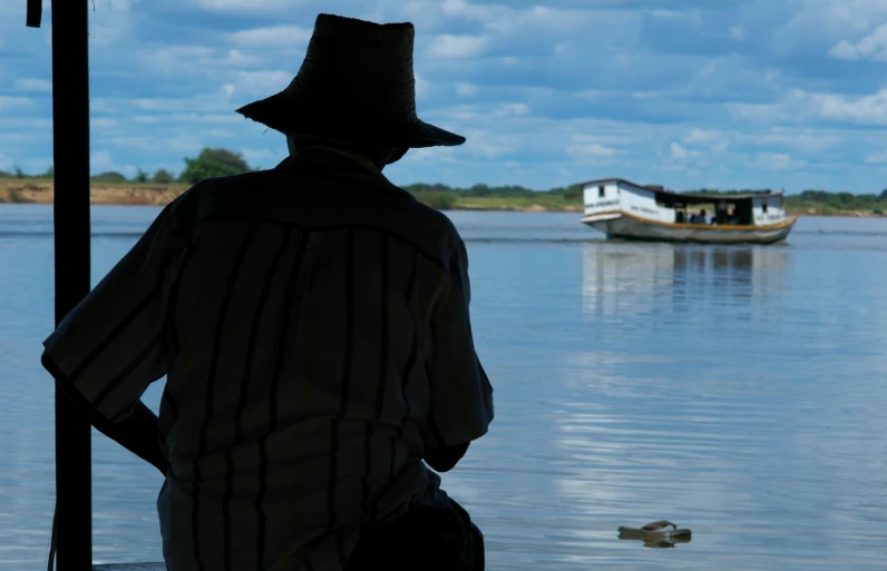 a man standing on a pier next to water