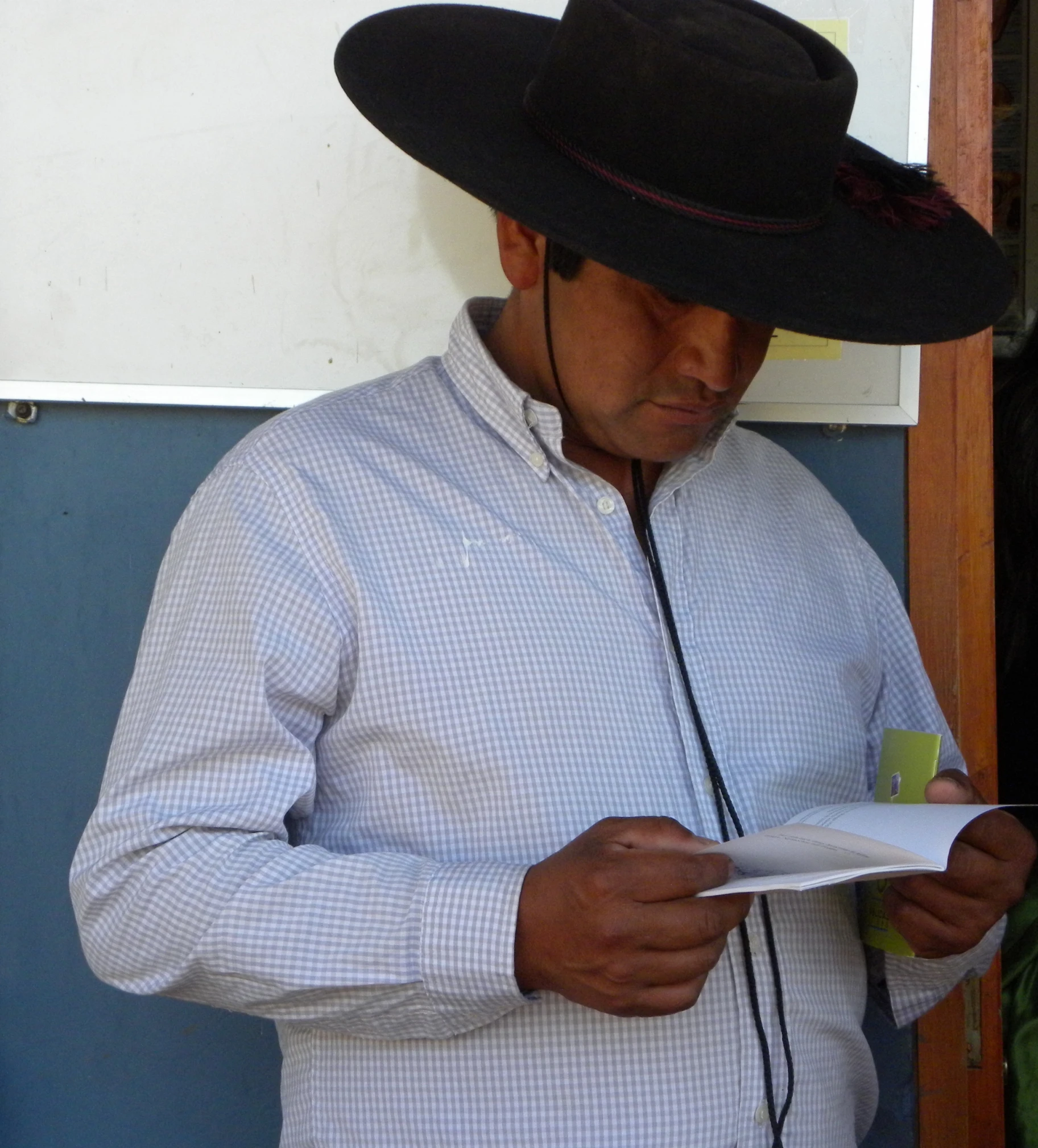 a man wearing a cowboy hat is reading a paper