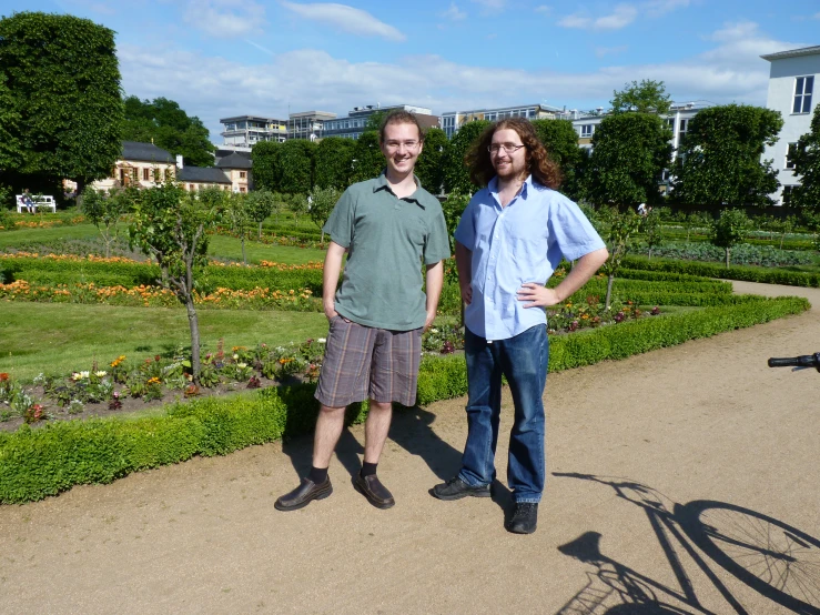 two men pose for a picture outside their house