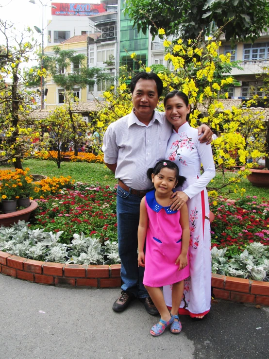 a family poses for the camera in a park with flowers