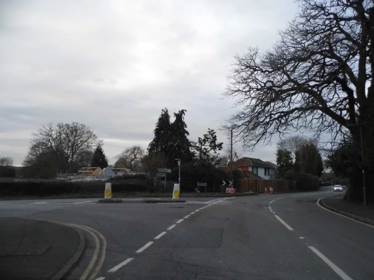 a deserted road with a few trees to the left