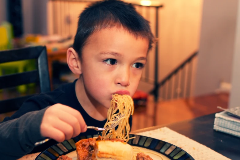 a  enjoying a meal of spaghetti and meat