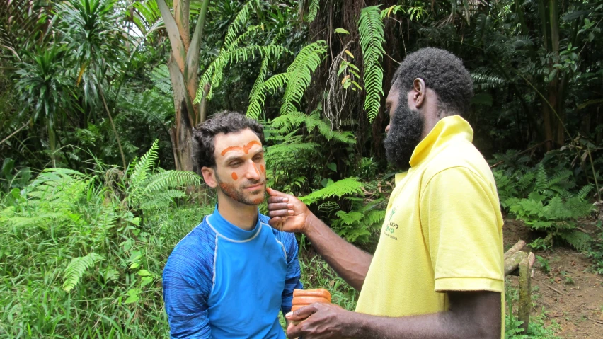 two men with painted faces standing next to each other