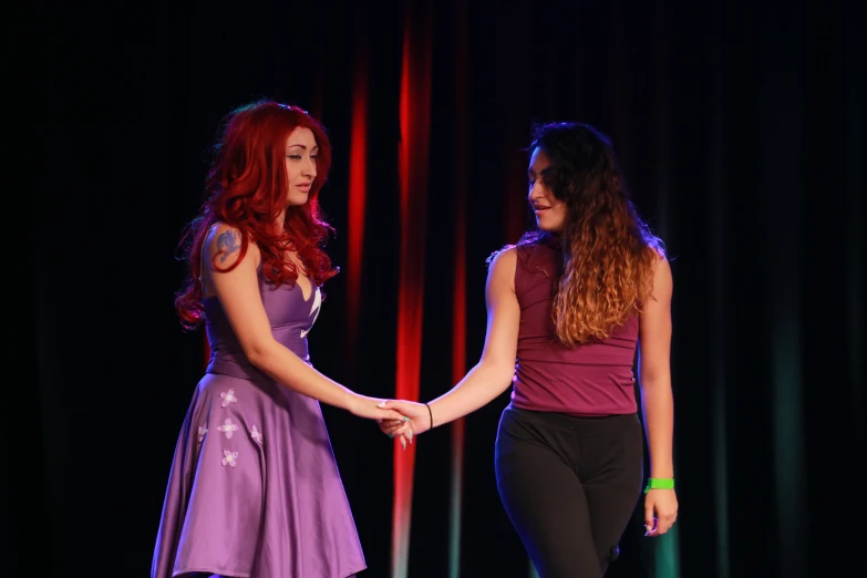two girls are shaking hands during a performance