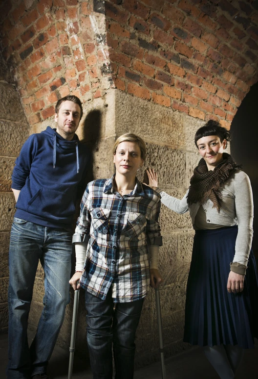 a group of three people stand with crutches on their hands