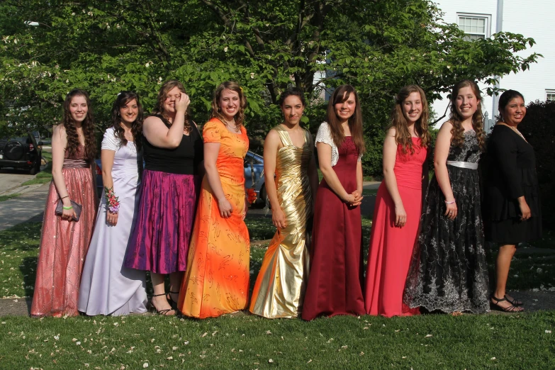 a group of people standing around each other wearing different dress styles