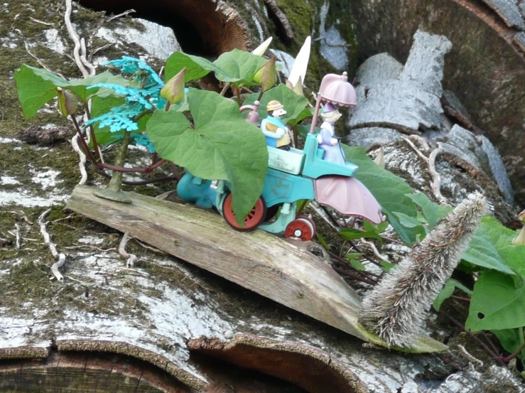 a small toy horse pulling a bug with some green leaves