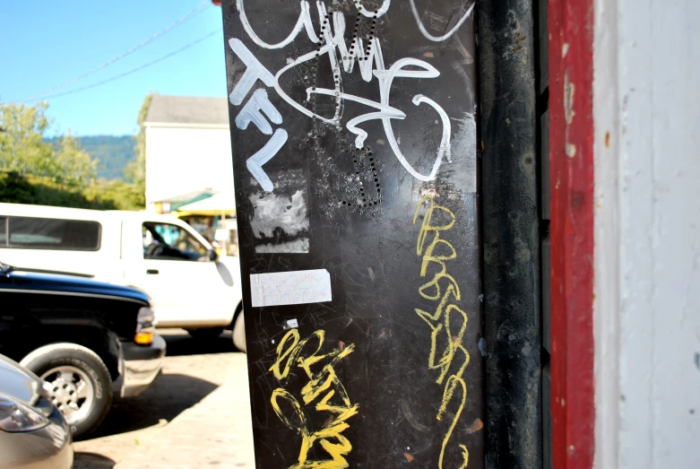 there is a black door covered with yellow graffiti