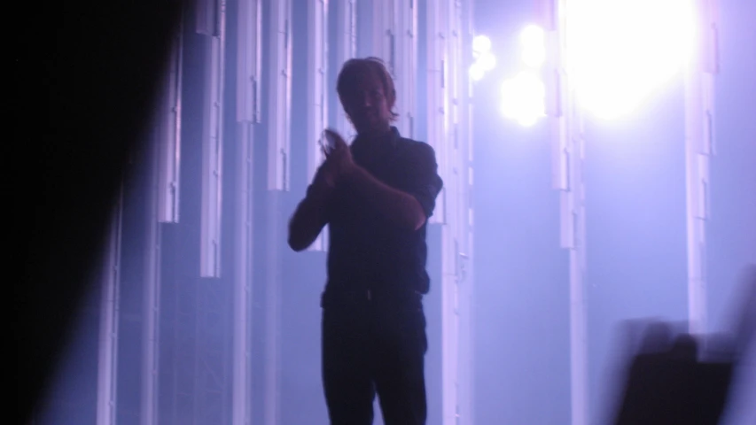 man standing in front of white curtain at night