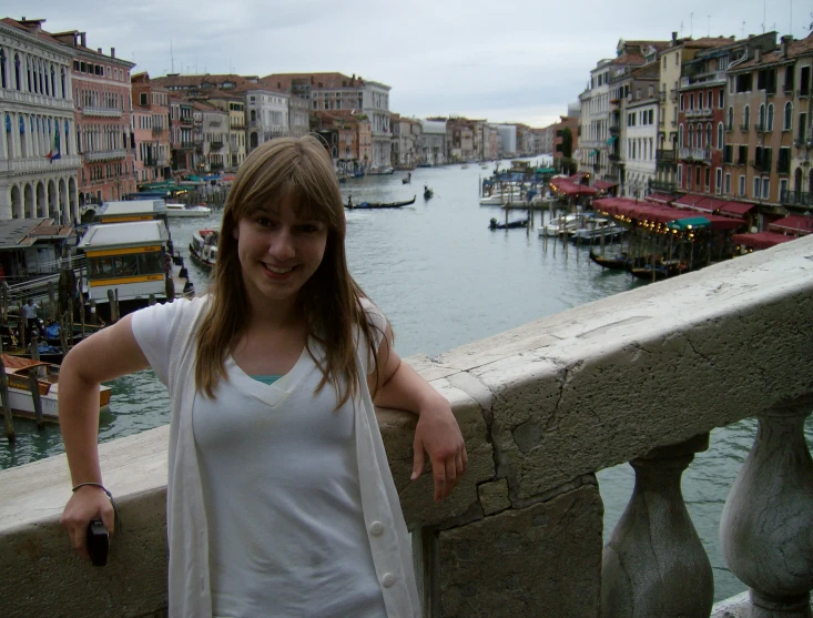 a woman posing near the water in a town