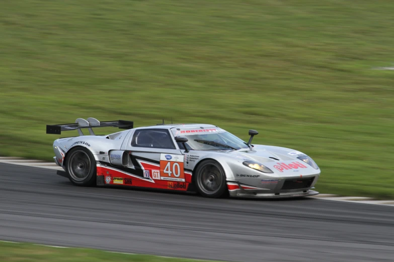 a race car with a number on it's front is driving down a race track